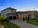 Beautiful two-story home with a stone accent, covered entryway, and a three-car garage at 16049 Volterra Pt, Bella Collina, FL 34756