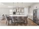 Open kitchen layout with island, stainless steel appliances and seamless transition to dining area at 16049 Volterra Pt, Bella Collina, FL 34756