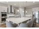 Sleek kitchen features white cabinets, stainless steel appliances, a large island with seating, and pendant lighting at 16049 Volterra Pt, Bella Collina, FL 34756
