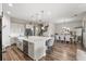 Modern kitchen island with seating, stainless steel appliances, and elegant pendant lighting, open to dining area at 16049 Volterra Pt, Bella Collina, FL 34756