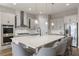 Modern kitchen showcases an island with bar seating and stainless steel appliances at 16049 Volterra Pt, Bella Collina, FL 34756