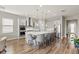 Modern kitchen features white cabinetry, stainless steel appliances, pendant lighting, and an island with seating for four at 16049 Volterra Pt, Bella Collina, FL 34756