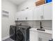 This laundry room features new cabinets and stainless steel washer and dryer units at 16049 Volterra Pt, Bella Collina, FL 34756
