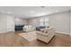 Living room with hardwood floors, neutral-colored walls, and three sofas at 16049 Volterra Pt, Bella Collina, FL 34756