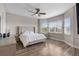 This main bedroom features wood floors, light gray walls, and plenty of natural light at 16049 Volterra Pt, Bella Collina, FL 34756