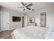 Main bedroom featuring wood floors, a large dresser, ceiling fan, and natural light at 16049 Volterra Pt, Bella Collina, FL 34756