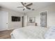 Spacious main bedroom featuring luxury vinyl floors, a TV, and an ensuite bathroom at 16049 Volterra Pt, Bella Collina, FL 34756