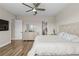 A view into the main bedroom which features wood floors, ensuite bath, and a dresser with mirror at 16049 Volterra Pt, Bella Collina, FL 34756