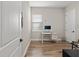 This bright home office has wood-look floors, a window, and a white desk at 16049 Volterra Pt, Bella Collina, FL 34756