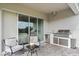 Outdoor kitchen area with a built-in grill and seating for outdoor entertaining at 16049 Volterra Pt, Bella Collina, FL 34756