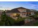 Well-maintained rear exterior with a covered patio, lush green lawn, and decorative landscaping at 16049 Volterra Pt, Bella Collina, FL 34756