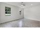 Bright bedroom with wood-look tile flooring and two windows offering natural light at 2211 Simmons St, Leesburg, FL 34748