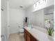 Bright bathroom featuring a cherry vanity, neutral countertop, and a large mirror with vanity lighting above at 2461 Bulrush Dr, St Cloud, FL 34769