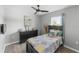 Cozy bedroom featuring a wood dresser and queen bed complemented by modern ceiling fan and natural light at 2461 Bulrush Dr, St Cloud, FL 34769