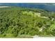 The property features lush trees, a well-manicured lawn, and a large body of water nearby at 2471 Jenscot Rd, St Cloud, FL 34771