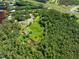 An aerial view of the property with a home, pond, trees and greenery next to a busy interstate at 2471 Jenscot Rd, St Cloud, FL 34771