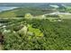 Aerial view showcases a home with ponds, trees and lush greenery, near roads and commercial buildings at 2471 Jenscot Rd, St Cloud, FL 34771