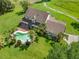 Aerial view of the property featuring a pool, screened porch, and well-manicured lawn at 2471 Jenscot Rd, St Cloud, FL 34771