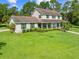 Charming two-story home featuring a welcoming front porch, lush lawn, and mature trees at 2471 Jenscot Rd, St Cloud, FL 34771