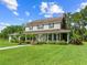 Beautiful two-story home featuring a welcoming covered porch and lush landscaping at 2471 Jenscot Rd, St Cloud, FL 34771