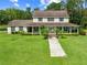Charming two-story home featuring a welcoming front porch, lush lawn, and mature trees at 2471 Jenscot Rd, St Cloud, FL 34771
