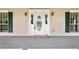 Elegant front door with an oval window, flanked by sconces and dark green shuttered windows at 2471 Jenscot Rd, St Cloud, FL 34771