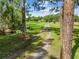 A long tree lined driveway leading to a home surrounded by a beautiful lawn and pond on the left at 2471 Jenscot Rd, St Cloud, FL 34771