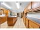 Open-concept kitchen with tile flooring, wooden cabinetry, and stainless steel appliances at 2471 Jenscot Rd, St Cloud, FL 34771