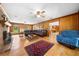 Spacious living room with wood paneling, hardwood floors, and brick fireplace at 2471 Jenscot Rd, St Cloud, FL 34771