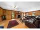 Cozy living room featuring a brick fireplace, wood paneling, and hardwood floors at 2471 Jenscot Rd, St Cloud, FL 34771