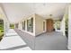 Long, covered porch featuring neutral siding and white pillars, with views of the yard at 2471 Jenscot Rd, St Cloud, FL 34771