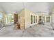 Spacious enclosed porch featuring ceiling fans, concrete floors, and ample natural light from the surrounding windows at 2471 Jenscot Rd, St Cloud, FL 34771