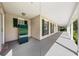 Long, covered porch featuring neutral siding and white pillars, with views of the yard at 2471 Jenscot Rd, St Cloud, FL 34771