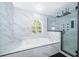 Beautiful bathroom featuring a soaking tub, glass shower, arched window and stylish fixtures at 2503 Calla Lily Cv, Kissimmee, FL 34758
