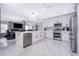 Modern kitchen with stainless steel appliances, a kitchen island, and sleek white cabinetry at 2503 Calla Lily Cv, Kissimmee, FL 34758