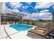Inviting screened-in pool area with lounge chairs and a serene water view, perfect for outdoor relaxation at 2503 Calla Lily Cv, Kissimmee, FL 34758