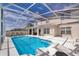 Backyard with a beautiful screened-in pool, a patio with lounge chairs, and views of the home at 2503 Calla Lily Cv, Kissimmee, FL 34758