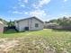 Backyard with green grass, partial shade, and a freshly painted exterior at 2629 Williston Dr, Lakeland, FL 33801