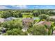 Aerial view of home with a basketball court and a large, green backyard surrounded by trees at 2722 Corybrooke Ln, Kissimmee, FL 34744