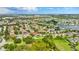 Wide aerial view showcasing a neighborhood, mature trees, and a lake in the distance at 2722 Corybrooke Ln, Kissimmee, FL 34744