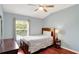 Well-lit bedroom with wood floors, a queen-sized bed, modern ceiling fan and ample natural light at 2722 Corybrooke Ln, Kissimmee, FL 34744