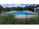 Large rectangular community pool with lounge chairs and a manicured fence and landscaping at 2722 Corybrooke Ln, Kissimmee, FL 34744