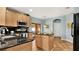 Bright kitchen featuring stainless steel appliances, black countertops, wooden cabinetry, and dining area at 2722 Corybrooke Ln, Kissimmee, FL 34744