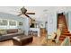 Open living room with tile flooring, ceiling fan, breakfast bar, and wooden staircase leading to the second floor at 2722 Corybrooke Ln, Kissimmee, FL 34744