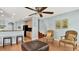 Open living room with tile flooring, breakfast bar, modern ceiling fan, and staircase leading upstairs at 2722 Corybrooke Ln, Kissimmee, FL 34744