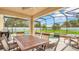 Covered patio features a dining table, chairs, and views of the pool and backyard at 2722 Corybrooke Ln, Kissimmee, FL 34744