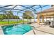 Sparkling pool with screened-in enclosure, an adjacent spa, and outdoor seating area at 2722 Corybrooke Ln, Kissimmee, FL 34744
