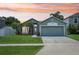 Charming single-story home with a well-manicured lawn and tropical palm trees against an orange sunset sky at 3038 Elbib, St Cloud, FL 34769