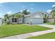 Charming single-story home with a well-manicured lawn and tropical palm trees under a blue sky at 3038 Elbib, St Cloud, FL 34769