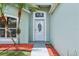 Close-up of the front door with decorative glass and a well-landscaped yard with mulch at 3038 Elbib, St Cloud, FL 34769